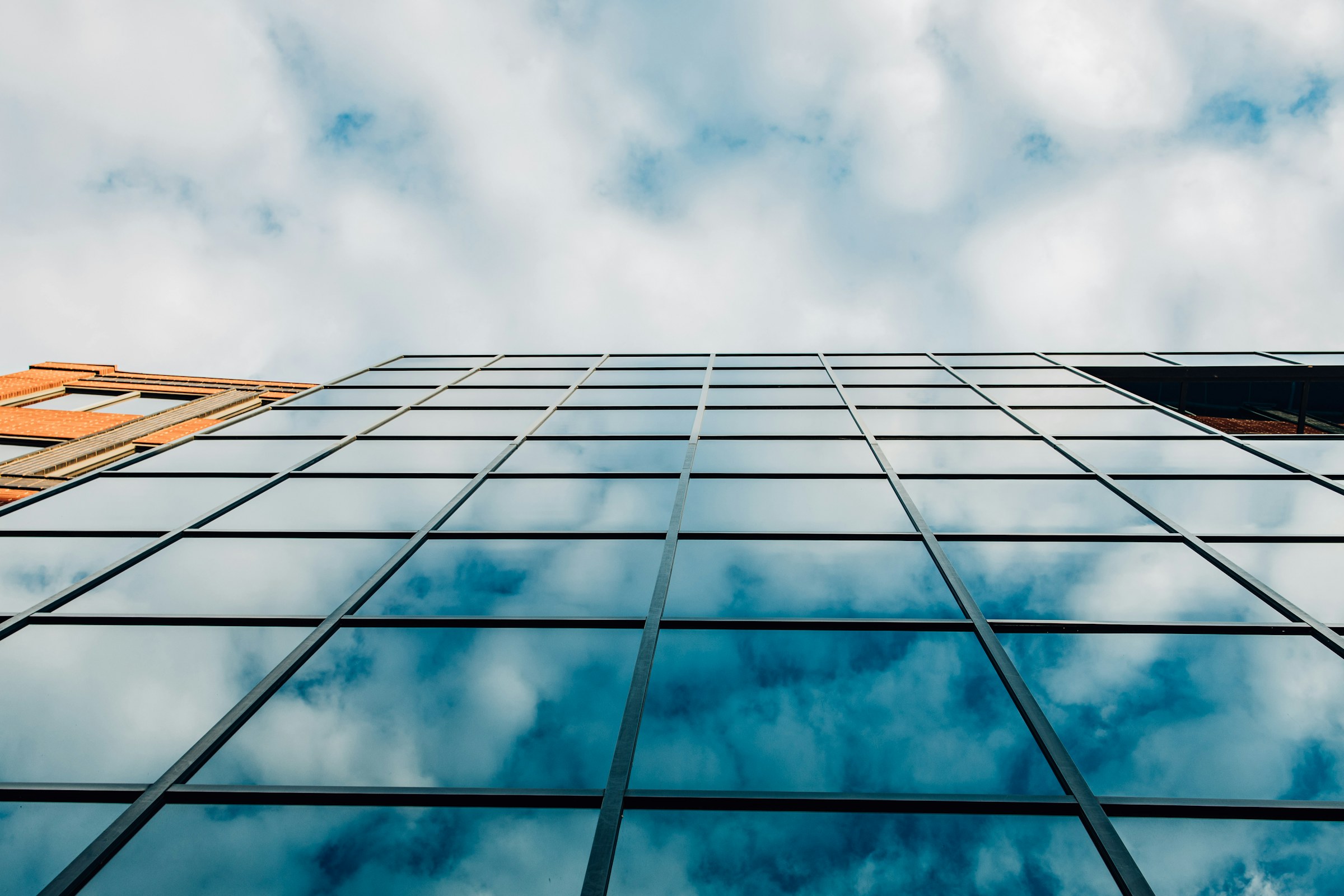 Modern glass architecture reflecting an open sky